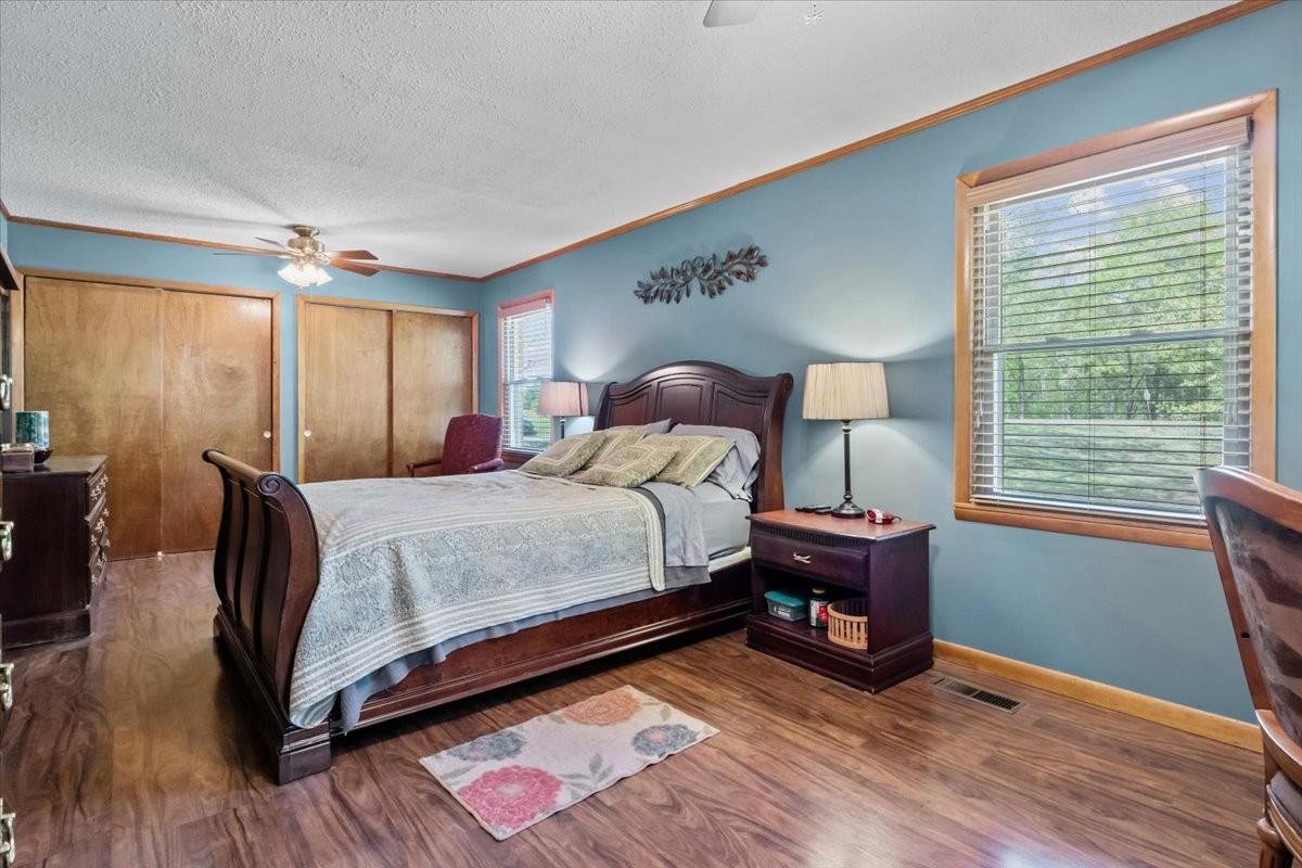 48 Hill Road Big Sandy, TN 38221 - Photo 17 of 54 a bedroom with a bed and wooden floor