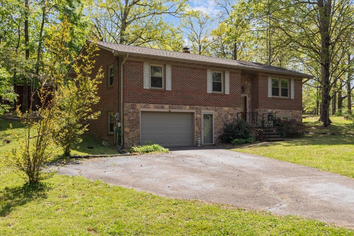 48 Hill Road Big Sandy, TN 38221 - Photo 27 of 54 a front view of a house with a yard and garage