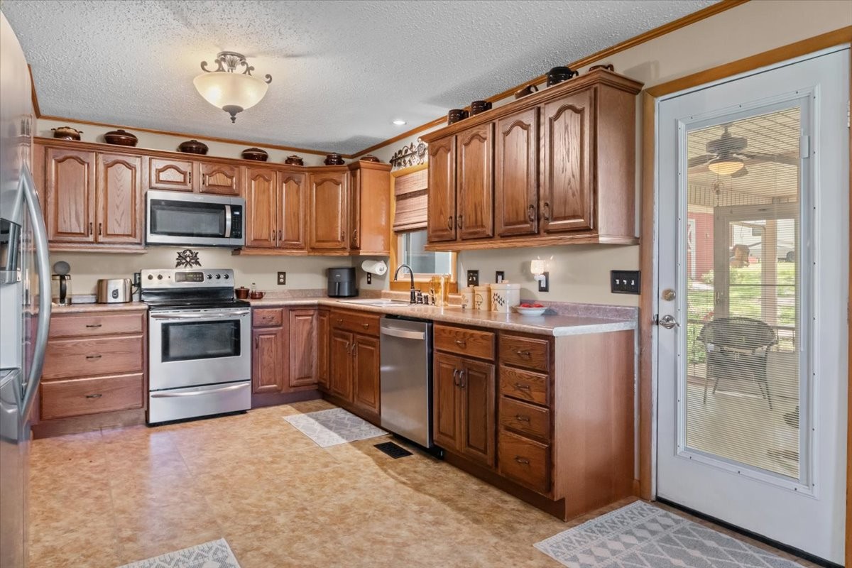 48 Hill Road Big Sandy, TN 38221 - Photo 10 of 54 a kitchen with granite countertop a refrigerator stove top oven a sink and dishwasher