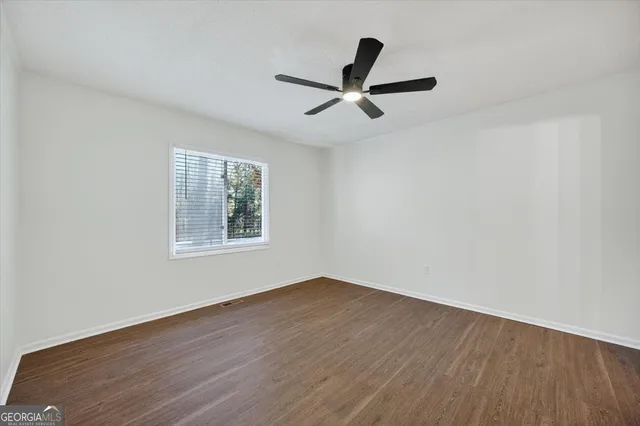 a view of a big room with wooden floor a ceiling fan and wooden floor