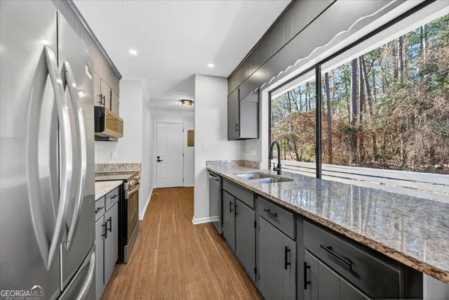a kitchen with stainless steel appliances a sink stove and refrigerator