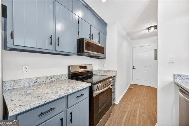 a kitchen with granite countertop wooden cabinets and a stove