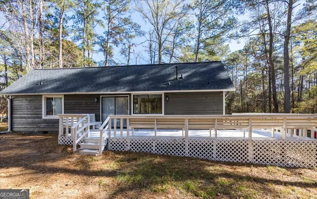 a view of house with backyard and a tree