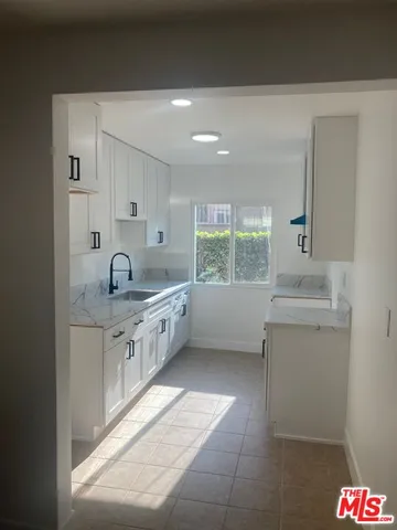 a kitchen with a sink cabinets and window