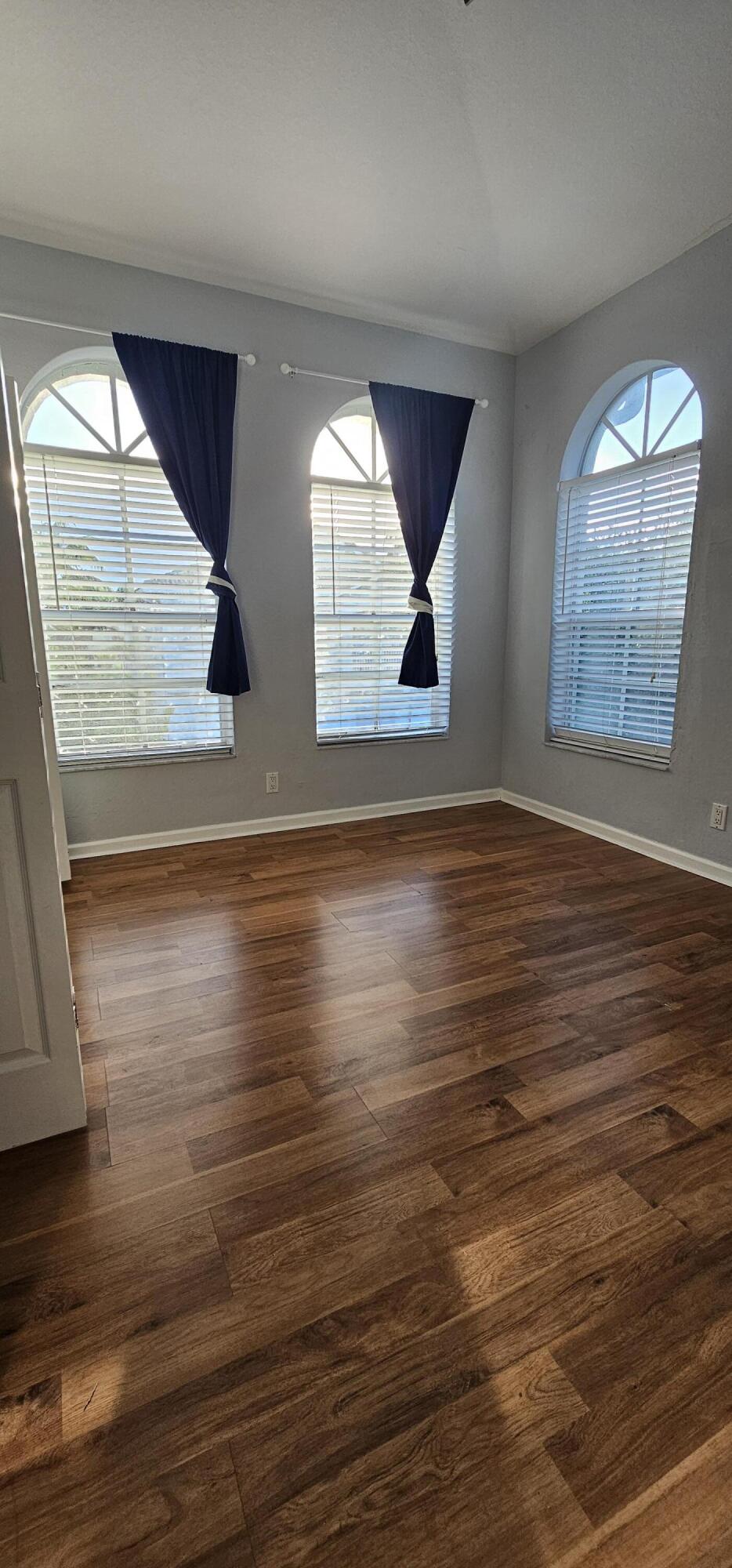 3078 Laurel Ridge Circle Riviera Beach, FL 33404 - Photo 12 of 13 an empty room with wooden floor and windows