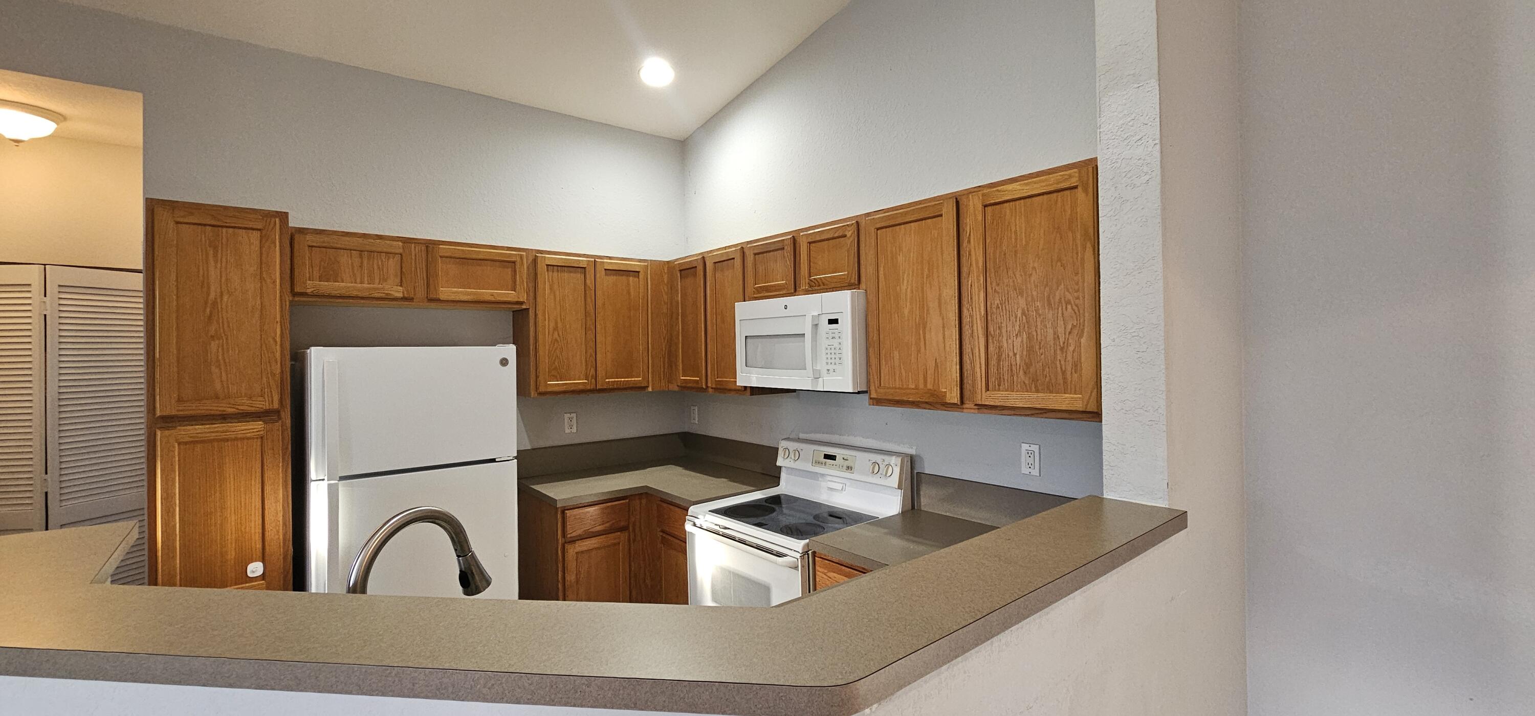 3078 Laurel Ridge Circle Riviera Beach, FL 33404 - Photo 3 of 13 a kitchen with a refrigerator and a sink