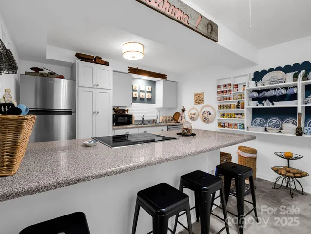a kitchen with refrigerator and chairs