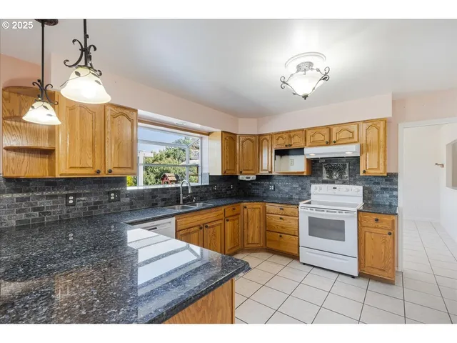 a kitchen with stainless steel appliances granite countertop a stove a sink and a microwave