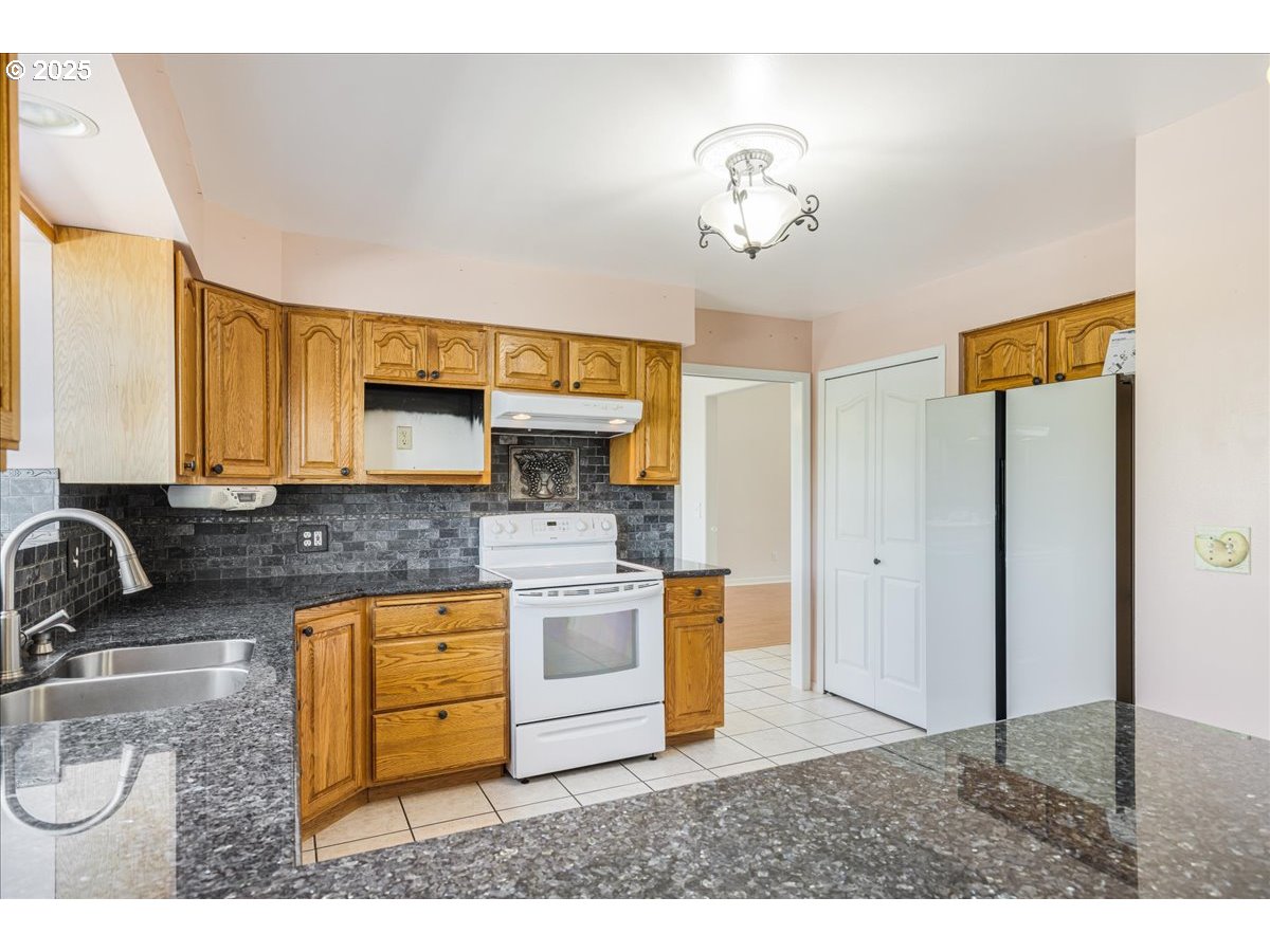 1825 Minnesota Street The Dalles, OR 97058 - Photo 14 of 47 a kitchen with stainless steel appliances granite countertop a sink and a refrigerator