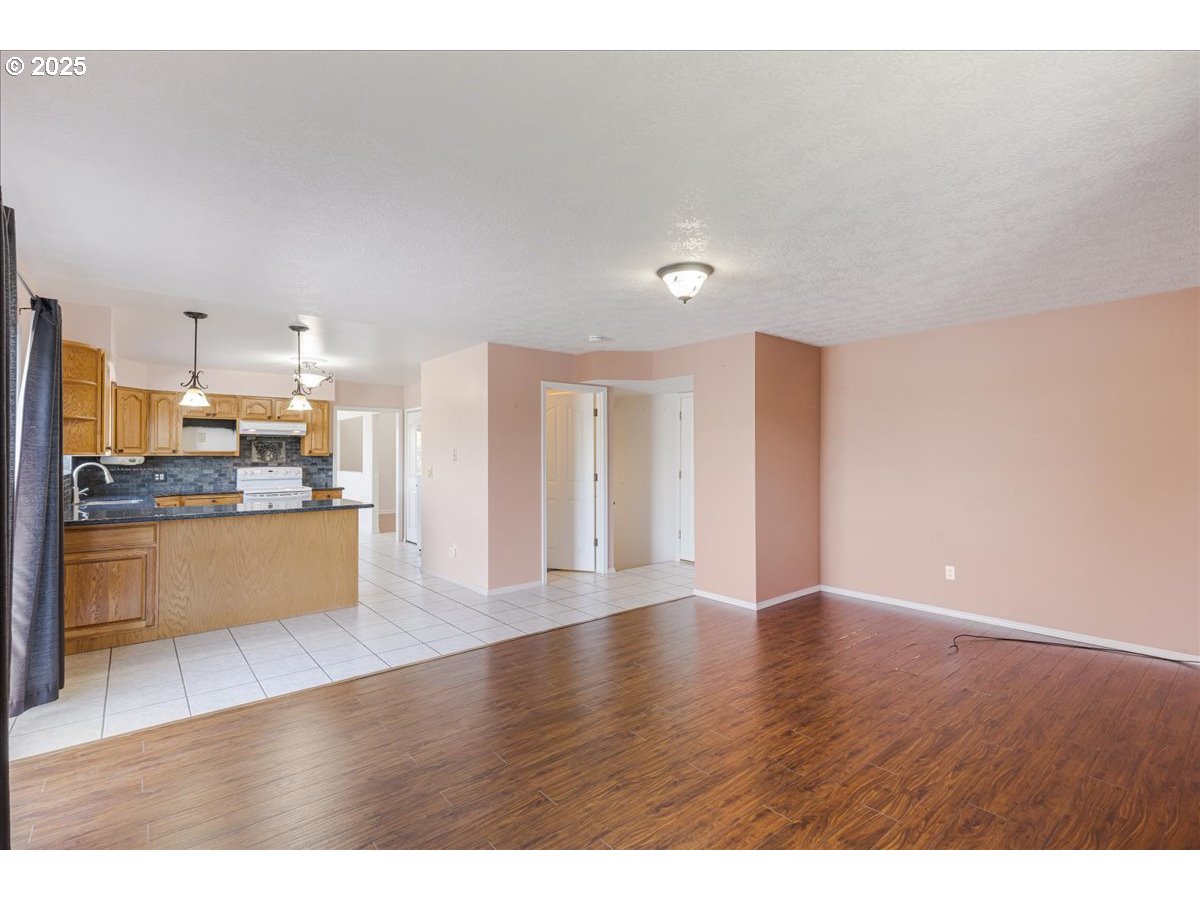1825 Minnesota Street The Dalles, OR 97058 - Photo 15 of 47 a view of a kitchen with refrigerator and wooden floor