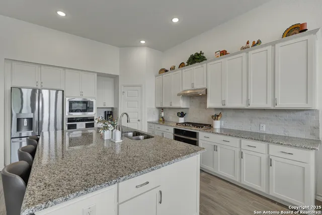 a kitchen with white cabinets and stainless steel appliances