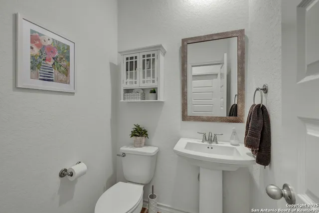 a bathroom with a toilet sink and mirror