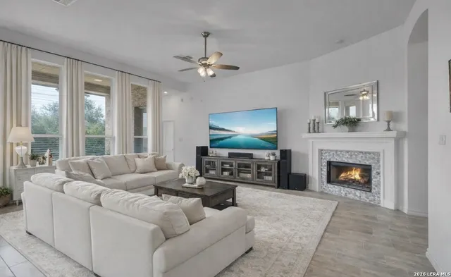 a living room with furniture a fireplace and a flat screen tv