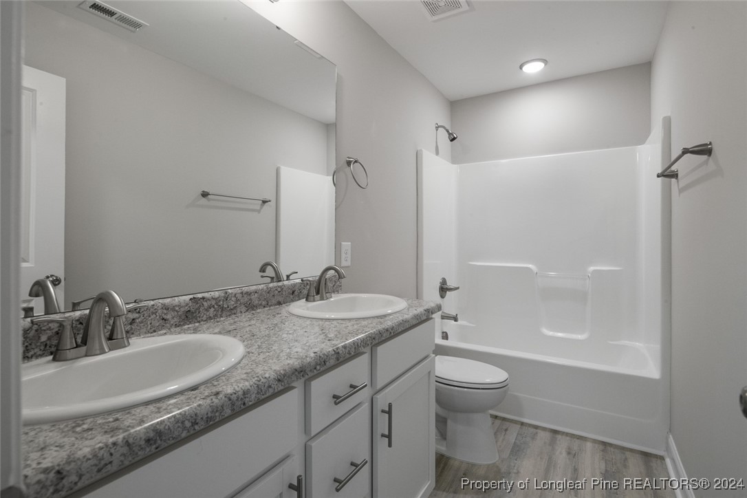 57 3rd Street Parkton, NC 28371 - Photo 14 of 24 a bathroom with a granite countertop sink a toilet and shower