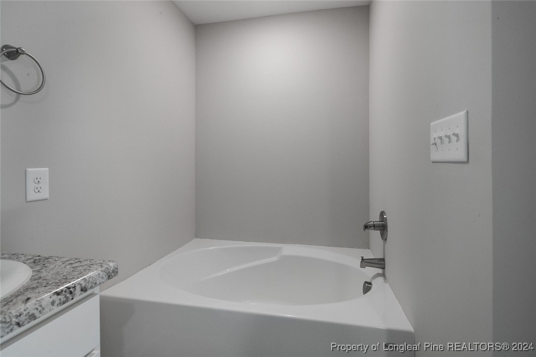 57 3rd Street Parkton, NC 28371 - Photo 18 of 24 a bathroom with a granite countertop sink and vanity