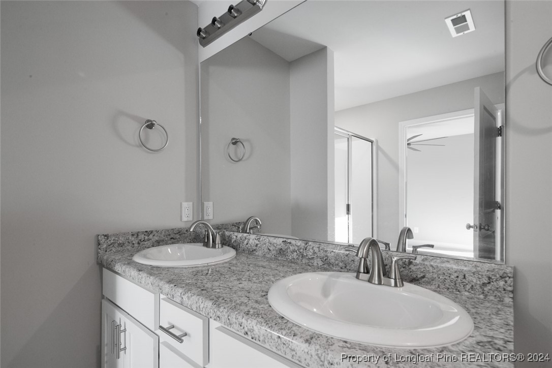 57 3rd Street Parkton, NC 28371 - Photo 20 of 24 a bathroom with a granite countertop sink a mirror and shower