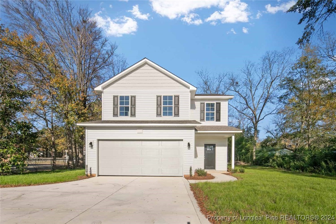 57 3rd Street Parkton, NC 28371 - Photo 2 of 24 a front view of a house with a garden and trees