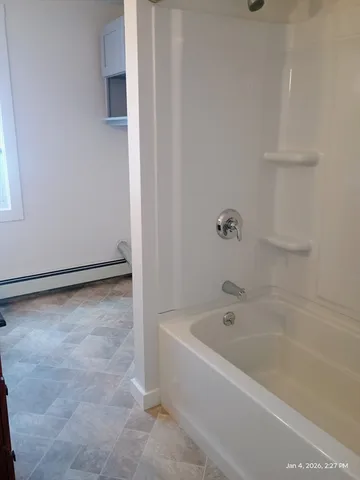 a white bath tub sitting next to a window