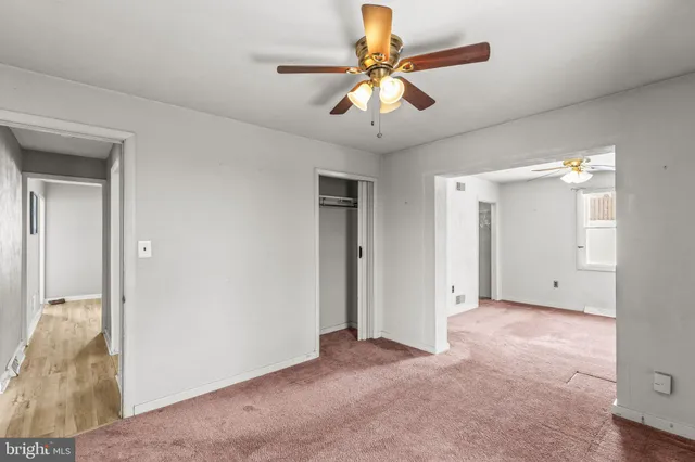 an empty room with chandelier fan