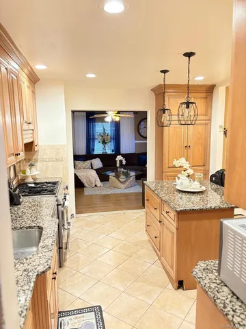 a kitchen with stainless steel appliances granite countertop a stove a sink and a refrigerator