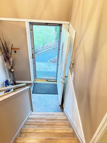 a view of front door with a sink and wooden floor