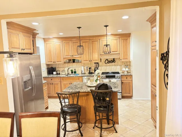 a kitchen with stainless steel appliances granite countertop a refrigerator and a stove top oven