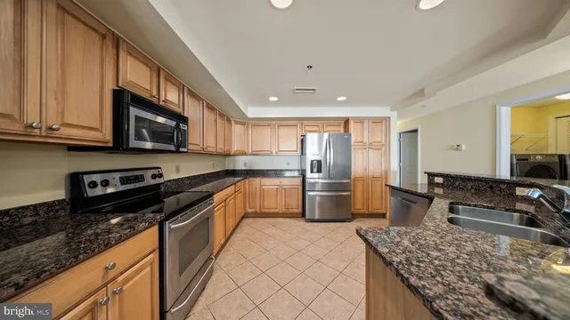 a kitchen with stainless steel appliances granite countertop a sink and cabinets