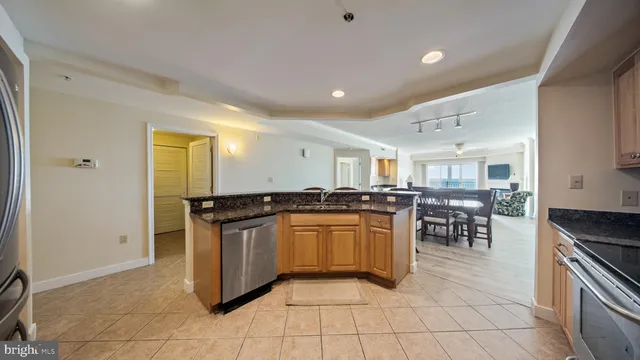 a kitchen with granite countertop white cabinets white stainless steel appliances and a sink