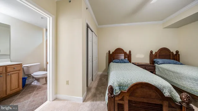 a view of a hallway with wooden floor and a bathroom
