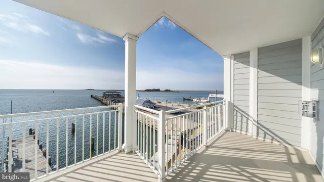 a kitchen with stainless steel appliances granite countertop a stove top oven a sink dishwasher and a refrigerator with wooden floor