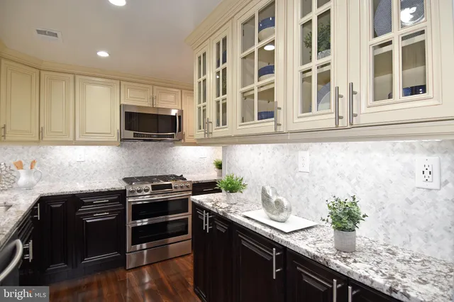 a kitchen with granite countertop a sink a stove and cabinets