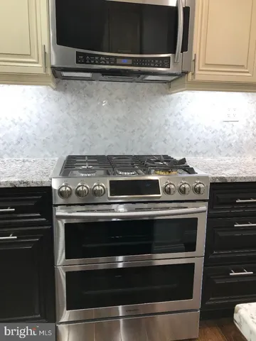 a kitchen with stainless steel appliances granite countertop wooden cabinets and a sink