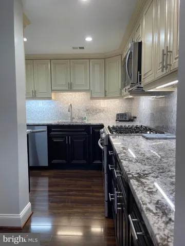 a metallic refrigerator freezer sitting in a kitchen