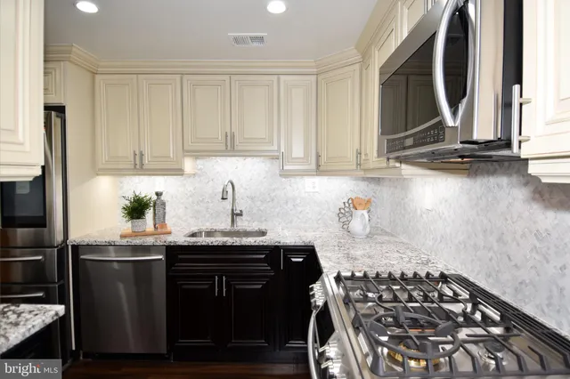 a kitchen with stainless steel appliances granite countertop a stove a sink and a granite counter tops