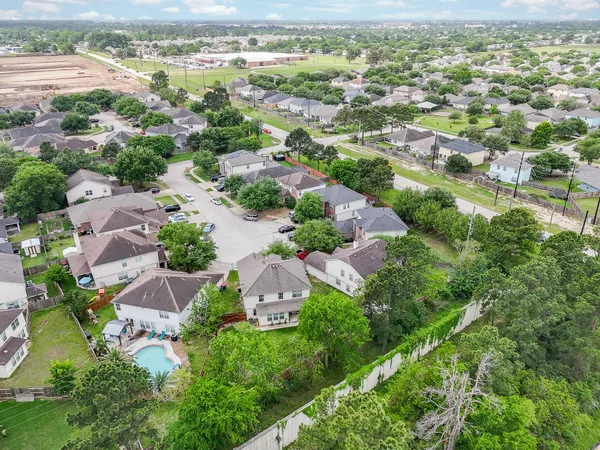 an aerial view of residential houses with outdoor space and trees