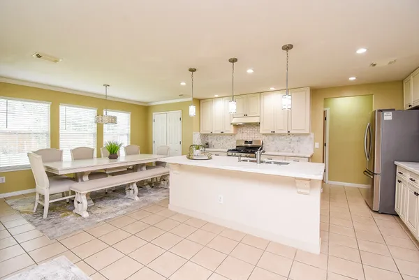a large kitchen with a table and chairs