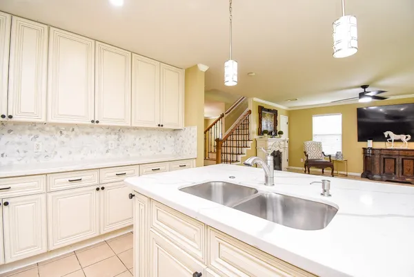 a kitchen with granite countertop a sink a stove and cabinets