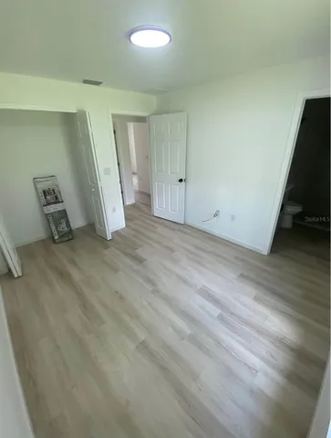 an empty room with wooden floor and sink