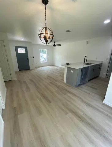 a view of a room with a ceiling fan and wooden floor