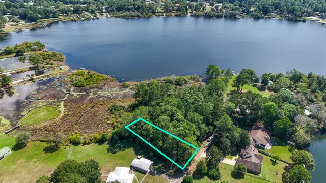 an aerial view of a house with a yard and lake view