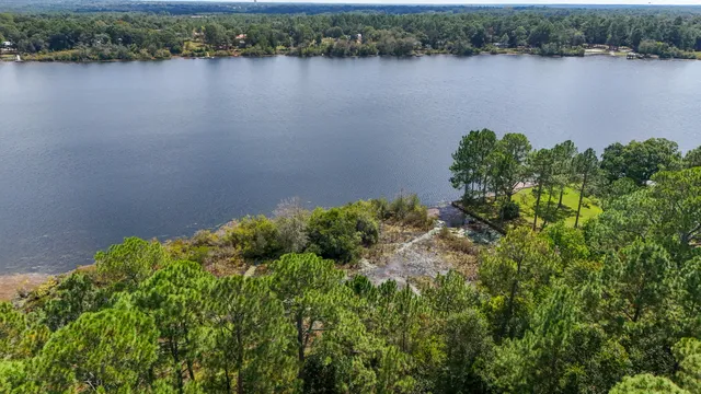 an aerial view of a residential houses with outdoor space and lake view