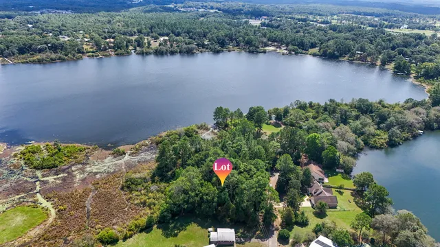 an aerial view of lake residential house with outdoor space and trees around