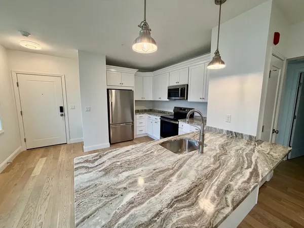 a large kitchen with kitchen island granite countertop a sink appliances and cabinets