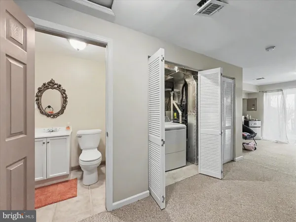a room with stainless steel appliances a rug and a view of bathroom