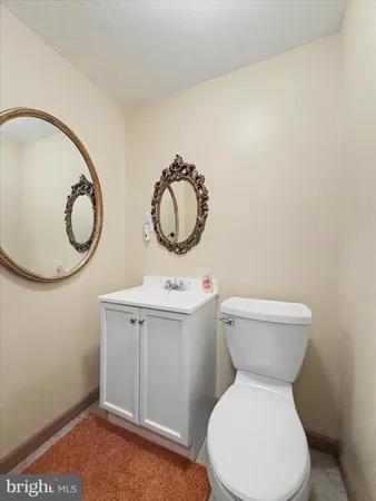 a bathroom with a toilet sink vanity and mirror