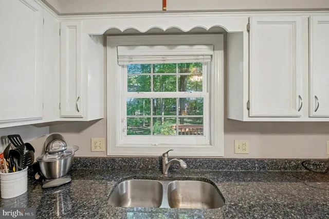 a kitchen with stainless steel appliances granite countertop a sink a stove a microwave and cabinets