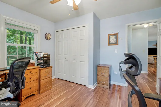 a view of a workspace with furniture and a window