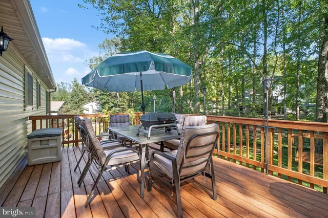 a view of wooden chairs and table under an umbrella