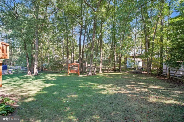 a view of a house with a big yard and large tree