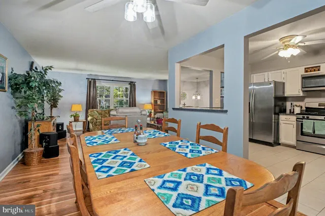 a view of a dining room with furniture a chandelier and wooden floor